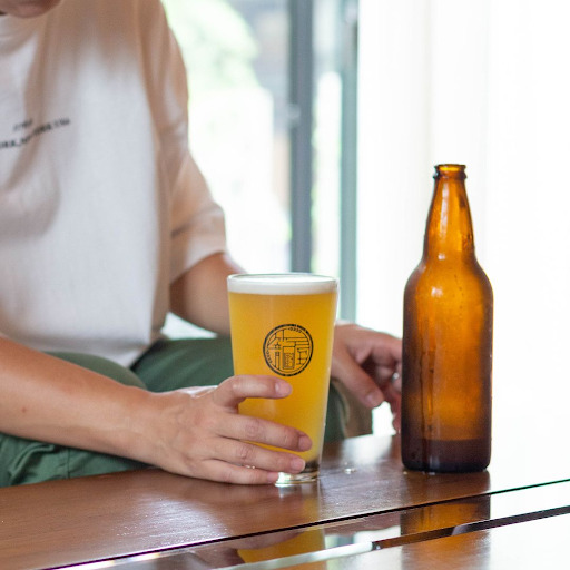 ビールグラスを持つ人の手とビール瓶
