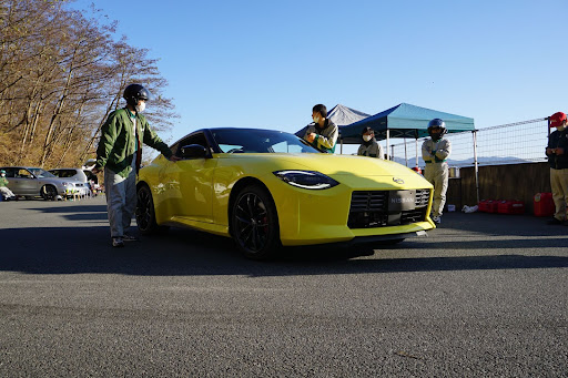 黄色の車を囲む5人の人