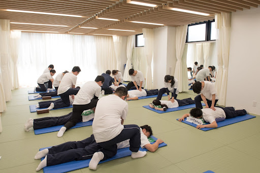 指圧練習をする多くの学生