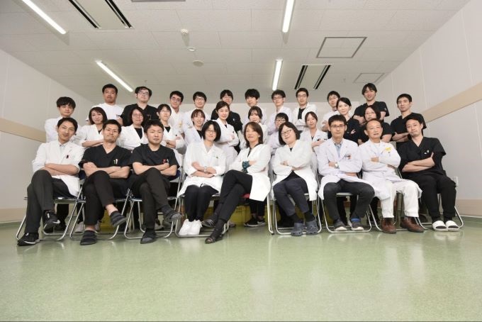 腕を組んで写真撮影する佐賀大学の薬剤師の先生たち