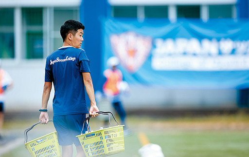 荷物を運ぶサッカー少年