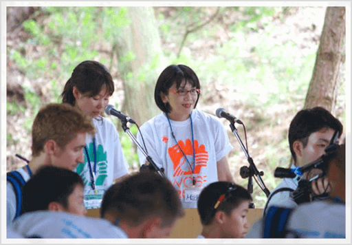 多くの人の前で2人の女性がスピーチする様子