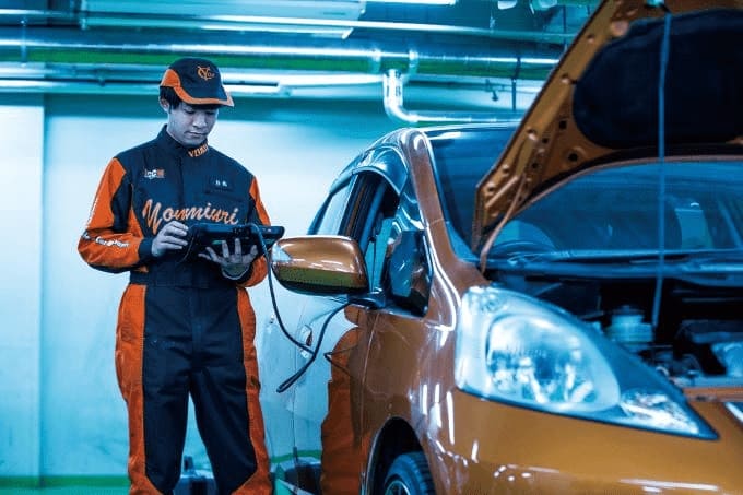 車の横に立つ整備学生