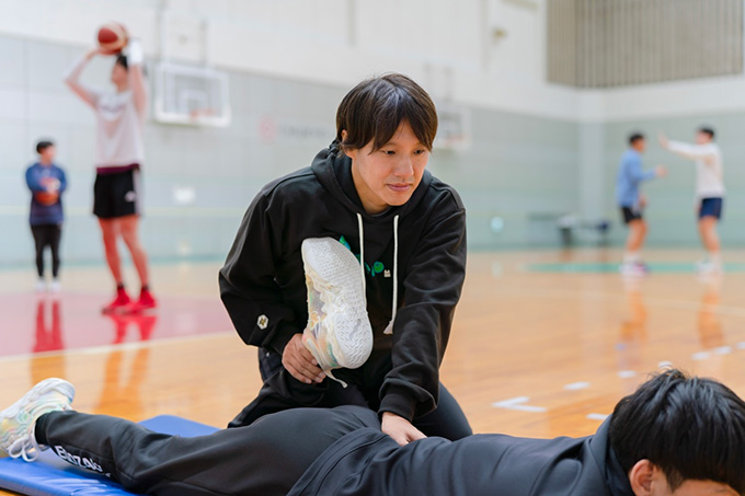 足のストレッチの補助をする男性